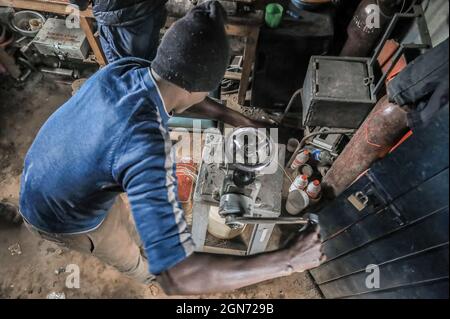 Nairobi, Kenia. September 2021. Ein Mitarbeiter des African Bone Craft bereitet ein Coli-Messing für die Herstellung von handgemachtem Schmuck in den Slums von Kibera in Nairobi zu.Eine Gruppe von Handwerkern des African Bone Craft in den Slums von Kibera in Nairobi verwendet recycelte Tierknochen, Hörner und Messingmetalle, um handgemachten Schmuck und Dekorationen zu kreieren, die später an Einheimische und Touristen verkauft werden, die manchmal die Werkstatt besuchen würden. Die African Bones begannen 2006 mit einer Gesamtzahl von 17 Gruppenmitgliedern, die beide vom Handwerksbetrieb abhängig sind, um ihren Lebensunterhalt zu verdienen. Sie haben trotz Challe auf dem Geschäft beharrt Stockfoto