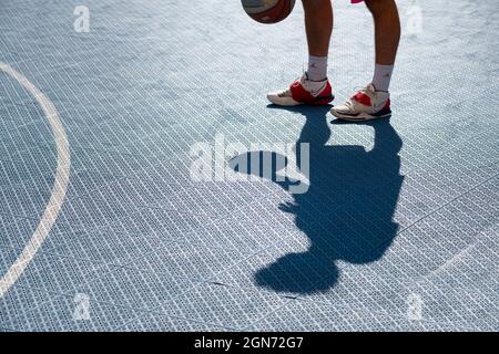 Yong man spielt Basketball auf dem Platz Stockfoto