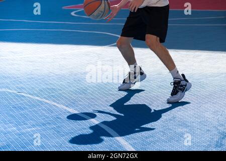 Yong man spielt Basketball auf dem Platz Stockfoto