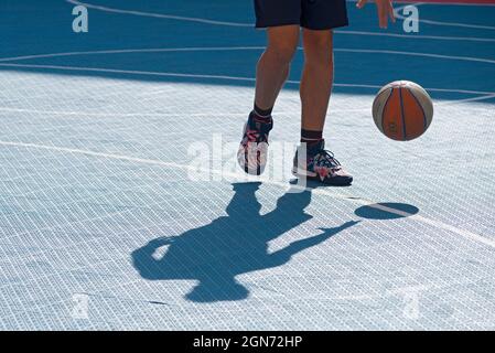 Yong man spielt Basketball auf dem Platz Stockfoto