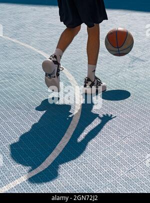 Yong man spielt Basketball auf dem Platz Stockfoto