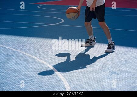 Yong man spielt Basketball auf dem Platz Stockfoto