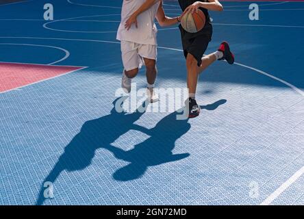 Yong man spielt Basketball auf dem Platz Stockfoto