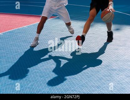 Yong man spielt Basketball auf dem Platz Stockfoto