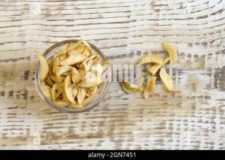 Getrocknete Knoblauch Flocken auf Glasplatte close up flach legen Foto auf weiß texturierten Holz Hintergrund Draufsicht Stockfoto