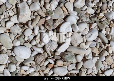 Ionische Küste, Kiesstrand mit Marmorstein, Nahaufnahme. Weiße und beige Farben Felsen auf der Insel Lefkada, Griechenland Stockfoto