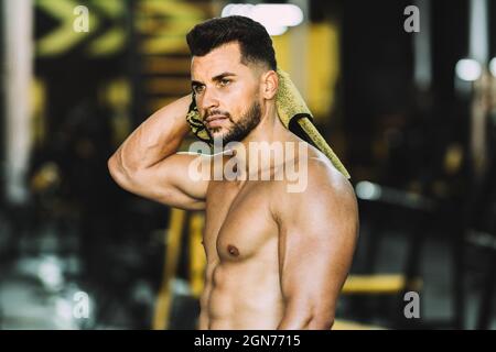 Porträt eines starken Mannes, der sich in einer Turnhalle mit einem Handtuch trocknet Stockfoto