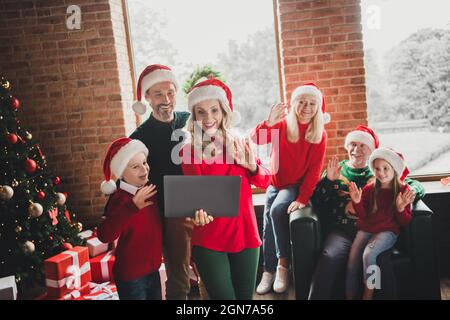 Fotoportrait, wenn Familie Weihnachten gemeinsam feiert, mit winkenden Händen über die Webcam mit dem Laptop spricht Stockfoto