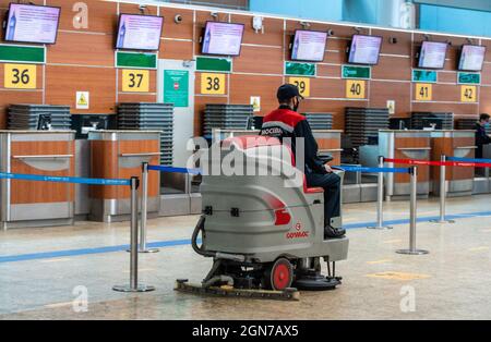 11. Mai 2021, Moskau, Russland. Ein Mitarbeiter mit Keilabsatz auf einer Scheuersaugmaschine im Passagierterminal des Flughafens Sheremetyevo. Stockfoto