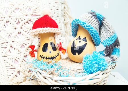 Zwei lustige Kürbisse in Kappen in einem Korb. Jacks Laternen. Ungewöhnliches Halloween, Humor. Stockfoto