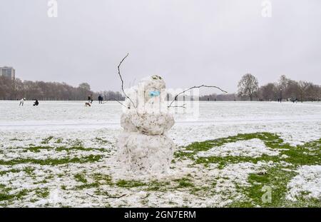 Ein Schneemann mit einer schützenden Gesichtsmaske während der Coronavirus-Pandemie an einem Tag starken Schnees im Hyde Park. London, Großbritannien 24. Januar 2021. Stockfoto