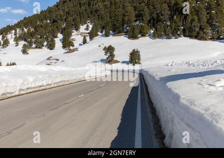 Saubere Straße mit viel Schnee auf der Seite von Lukmanier im Tessin, auf den Schweizer Alpen. Niemand drinnen Stockfoto