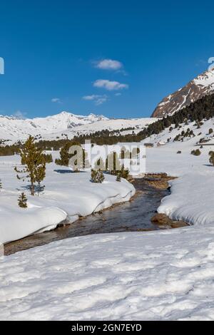 Panorama mit viel Schnee auf Lukmanier im Tessin, auf die Schweizer Alpen und ein romantischer Bach durch die Landschaft. Niemand drinnen Stockfoto