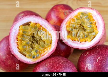 Ein Paar halbgeschnittener frischer reifer Passionsfrucht, isoliert auf dem ganzen Fruchtstapel Stockfoto