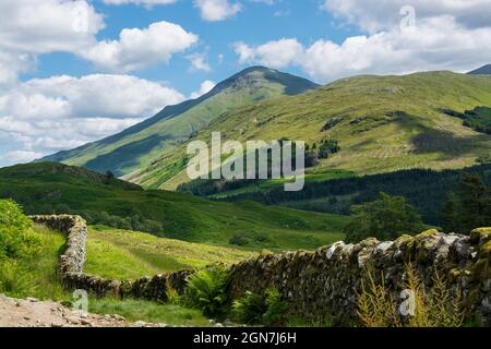 Entlang des West Highland Way in Schottland. Eine alte Steinmauer verläuft entlang des Wanderweges im Tal von Glen Falloch Stockfoto