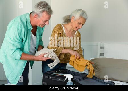 Kaukasisches Seniorenpaar packten Koffer zusammen und unterhielten sich im Schlafzimmer Stockfoto