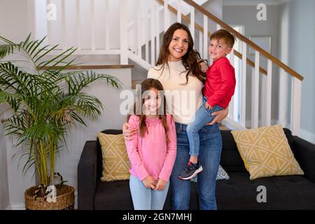 Glückliche kaukasische Mutter, Tochter und Sohn, die die Kamera anschauten Stockfoto