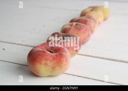 Paraguayische Pfirsiche auf weißer Holzoberfläche Stockfoto