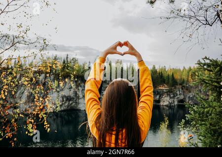 Marble Canyon in Ruskeala, Karelia mit Mädchen, die Hand Herz über Kopf zeigen. Stockfoto