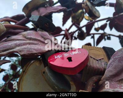Ein altes rotes herzförmiges rostiges Hochzeitsschloss, Konzept ewiger Liebe, ewiger Liebe, unsterblicher Liebe Stockfoto
