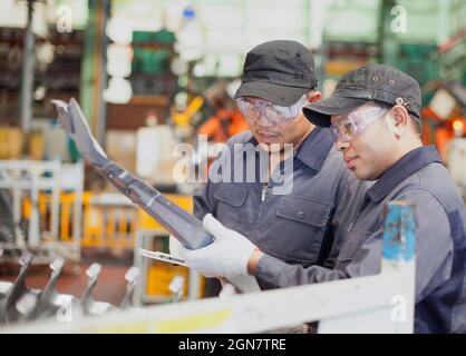 Zwei Techniker kontrollieren die Metallproduktion am Arbeitsplatz Stockfoto