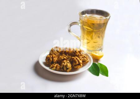 Walnuss und grüner Tee mit Zitronenblättern isoliert auf weißem Hintergrund Stockfoto
