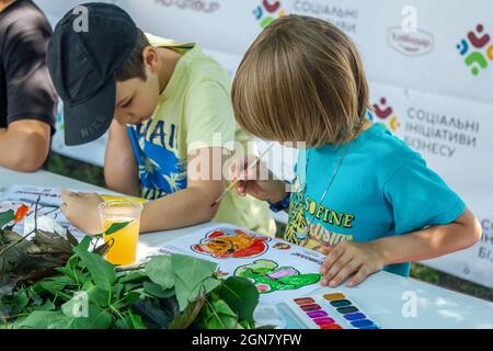 Zaporizhia, Ukraine- 19. Juni 2021: Charity Familienfest: Kinder nehmen an Kunst und Handwerk im Freien Workshop, machen bunte Zeichnung mit Stockfoto