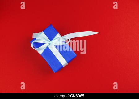 Geschenkschachtel auf rotem Hintergrund, von oben betrachtet Stockfoto