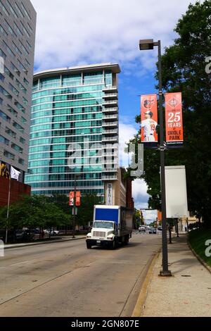 LKW, der das Zenith Wohngebäude passiert und ein Banner zur Feier des 25-jährigen Bestehens des Baltimore Orioles Baseballteams im Oriole Park, Baltimore, Maryland Stockfoto