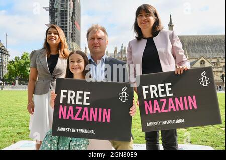 London, Großbritannien. Tulip Siddiq, Gabriella Ratcliffe, Richard Ratcliffe. Anlässlich des 2000. Tages der Inhaftierung von Nazanin Zaghari-Ratcliffe im Iran fand auf dem Parliament Square eine Fotoausstellung statt. Ein riesiges Schlangenbrett und ein Brett mit Leitern wurde verwendet, um die Höhen und Tiefen von Nazanins Fall zu zeigen. Stockfoto