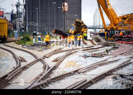 23. September 2021, Niedersachsen, Emden: Mit Lkw-Kranen wird ein entgleister Schienenkran mit einem Gewicht von mehr als 100 Tonnen angehoben. Der Eisenbahnkran entgleiste letzte Woche am Kai von Borkum und muss nun gerettet werden. Foto: Sina Schuldt/dpa Stockfoto