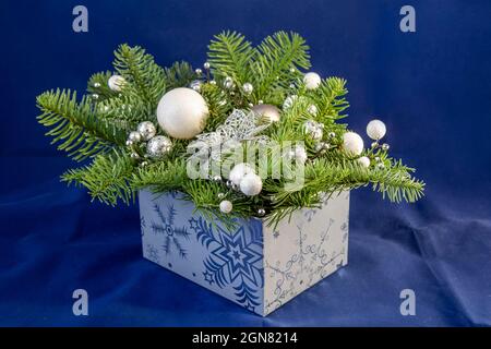 Blaue Box mit Tannenzapfen und weißen Kugeln Weihnachtsbaum. Weihnachtsschmuck zum Neujahr mit Tannenzapfen. Stockfoto