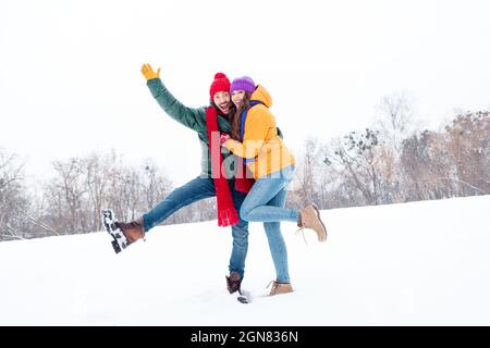 In voller Länge Foto von jungen schönen Paar glücklich positive Lächeln Umarmung Winterfrost Wetter Schnee draußen kuscheln Stockfoto