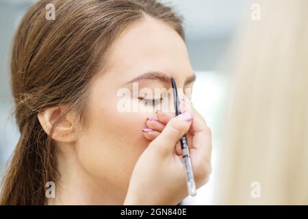 Professionelle Make-up-Künstler macht Make-up. Frau arbeitet in einem Friseursalon. Kleinunternehmen. Arbeitsplatz des Make-up-Künstlers. Stockfoto