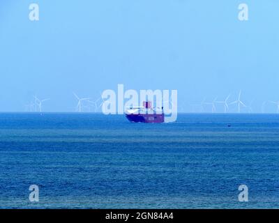 Minster on Sea, Kent, Großbritannien. September 2021. UK Wetter: Ein sonniger Nachmittag in Minster on Sea, Kent. Ein Transportschiff in der Themse-Mündung, dessen Turbinen vom Windpark London Array nur in der Ferne zu sehen sind. Kredit: James Bell/Alamy Live Nachrichten Stockfoto