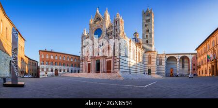 Siena, Italien. Wunderschöne Aussicht auf die Fassade und den campanile der Kathedrale von Siena, den Dom von Siena bei Sonnenaufgang, Siena, Toskana. Stockfoto