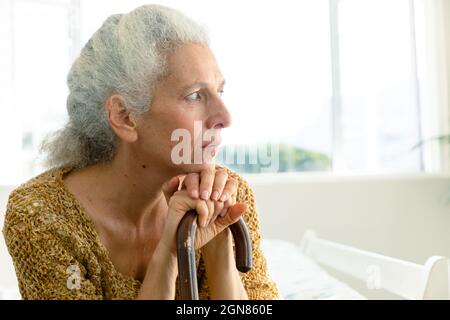 Profil einer nachdenklichen kaukasischen älteren Frau, die Rute hält und in die Ferne blickt Stockfoto