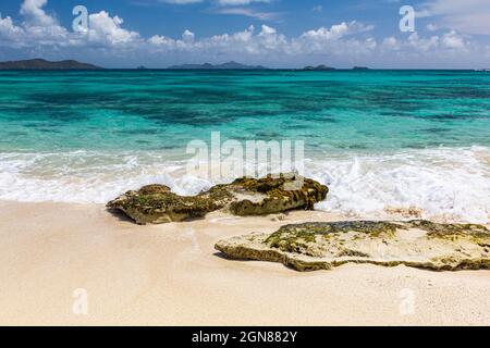 Karibische Insel Blick auf Mayreau und die Grenadinen von einem sandigen Palm Island Strand, mit Felsen, Türkisfarbenem Ozean und sanften Wellenlängsradien. Stockfoto