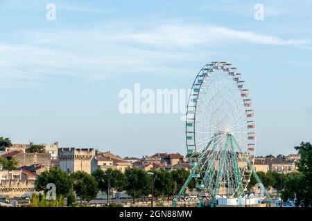 Avignon, Frankreich - Juli, 2021 : Riesenrad oder Panoramarad in Avignon mit historischem Denkmal im Hintergrund, mittelalterliche Stadtmauern mit Stockfoto