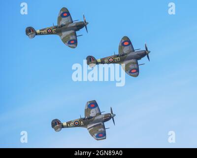 Die Morgendämmerung patrouilliert beim Goodwood Revival 2021, West Sussex, großbritannien, eine fliegende Formation von drei Spitfemes in einem blauen Himmel Stockfoto