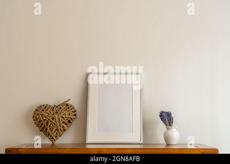 Nahaufnahme der Oberseite der Eiche Seitenwand mit imitierten silbernen Bilderrahmen, porzellan Topf und Lavendel Blumenarrangement in kleiner Vase Stockfoto