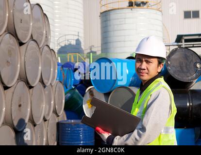 Porträt eines lächelnden, selbstbewussten Vorgesetzten, der die Lagertrommel im Lager kontrolliert Stockfoto