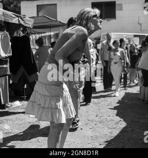 Sokobanja, Serbien, 19. Aug 2021: Eine Frau ist fasziniert von einem Stall auf einem Dorfmarkt Stockfoto