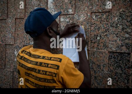 Mexiko Stadt, Mexiko. September 2021. Ein Migrant aus Haiti füllt in Mexiko vor der mexikanischen Kommission Refugee Assistance COMAR ein Asylbewerberformular aus. In den letzten drei Tagen sind in der mexikanischen Hauptstadt zahlreiche Menschen aus Haiti angekommen. Sie hoffen auf Asyl in Mexiko, während sich die Lage an der Grenze zu den USA verschlechtert. Quelle: Jair Cabrera Torres/dpa/Alamy Live News Stockfoto