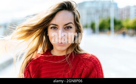 Blonde junge Frau in rotem Pullover Stockfoto