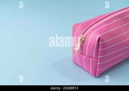 Pinkfarbene Bleistiftbox auf hellblauem Hintergrund. Stockfoto