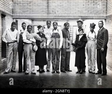 Acht der neun Scottsboro Boys, Ozie Powell, Olen Montgomery, William Roberson, Charles Weems, Clarence Norris, Haywood Patterson, Andrew Wright und Eugene Williams werden fälschlicherweise beschuldigt, zwei weiße Frauen vergewaltigt zu haben, zusammen mit den NAACP-Vertretern Juanita Jackson Mitchell, Laura Kellum und Dr. Ernest W. Taggart, Portrait Inside Prison, Alabama, USA, Britton & Patterson, 1936 Stockfoto