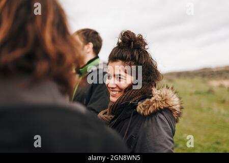 Lächelnde Frau, die eine Freundin auf dem Feld ansieht Stockfoto
