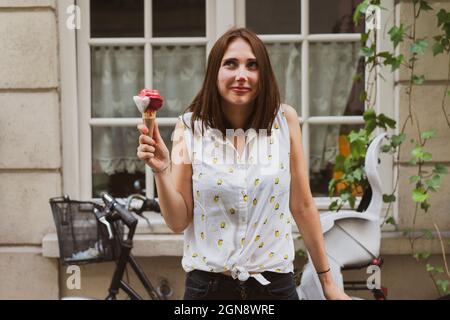 Lächelnde junge Frau mit Eis auf der Nase Stockfoto