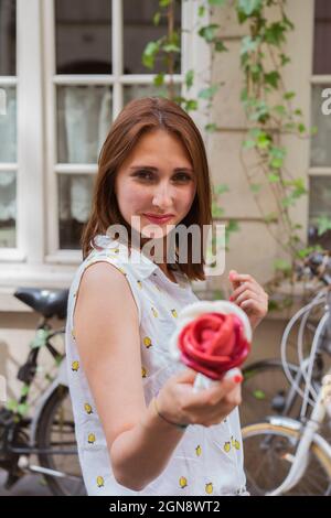 Lächelnde Frau mit braunem Haar, die Eis hält Stockfoto